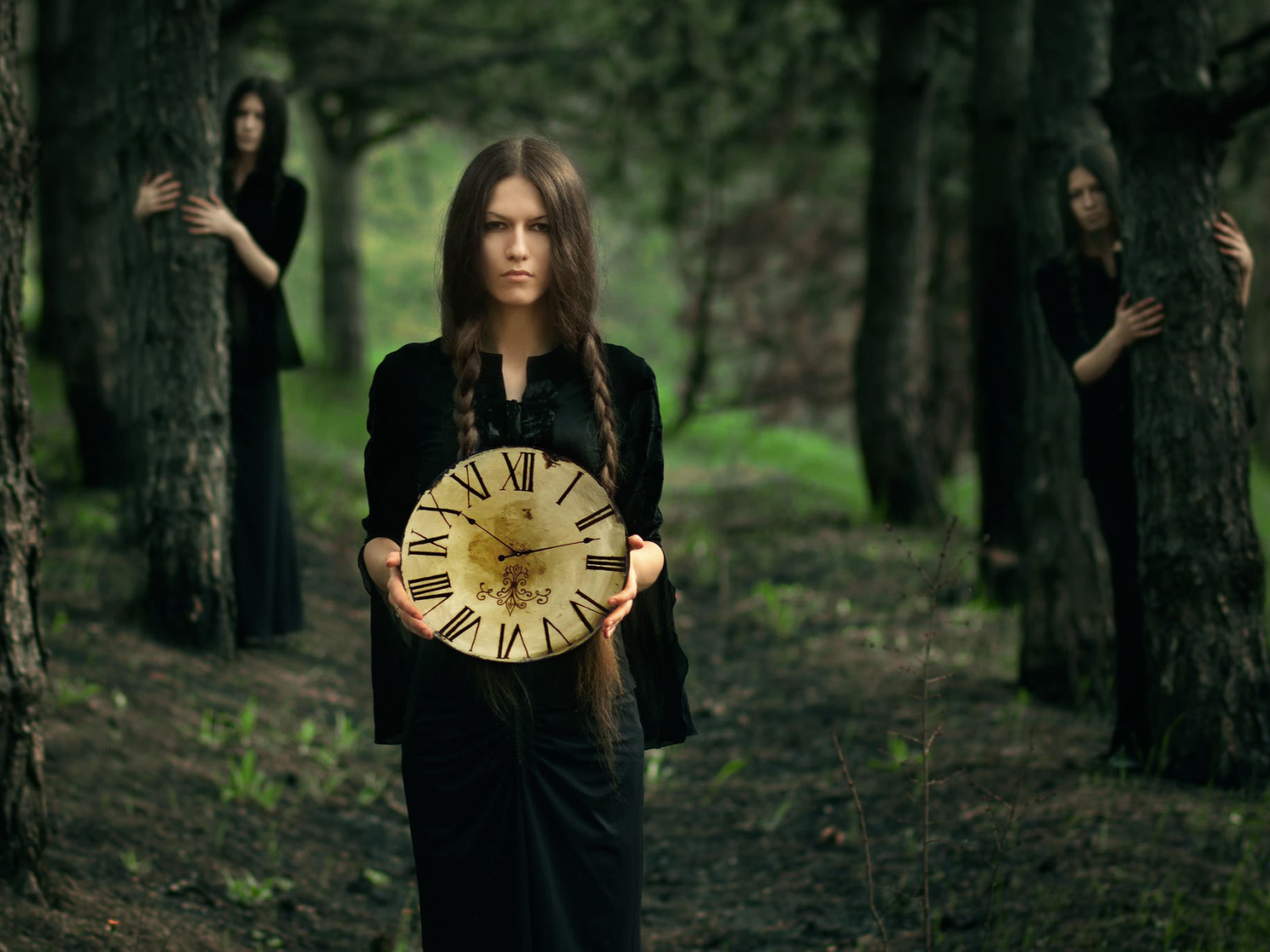 Девушка в черном платье держит часы в руках