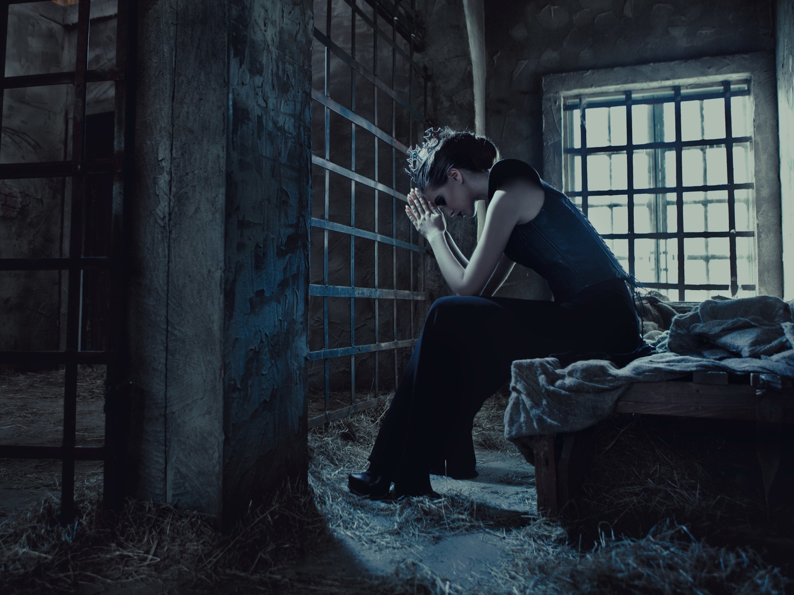 Девушка сидит за решеткой в тюрьме