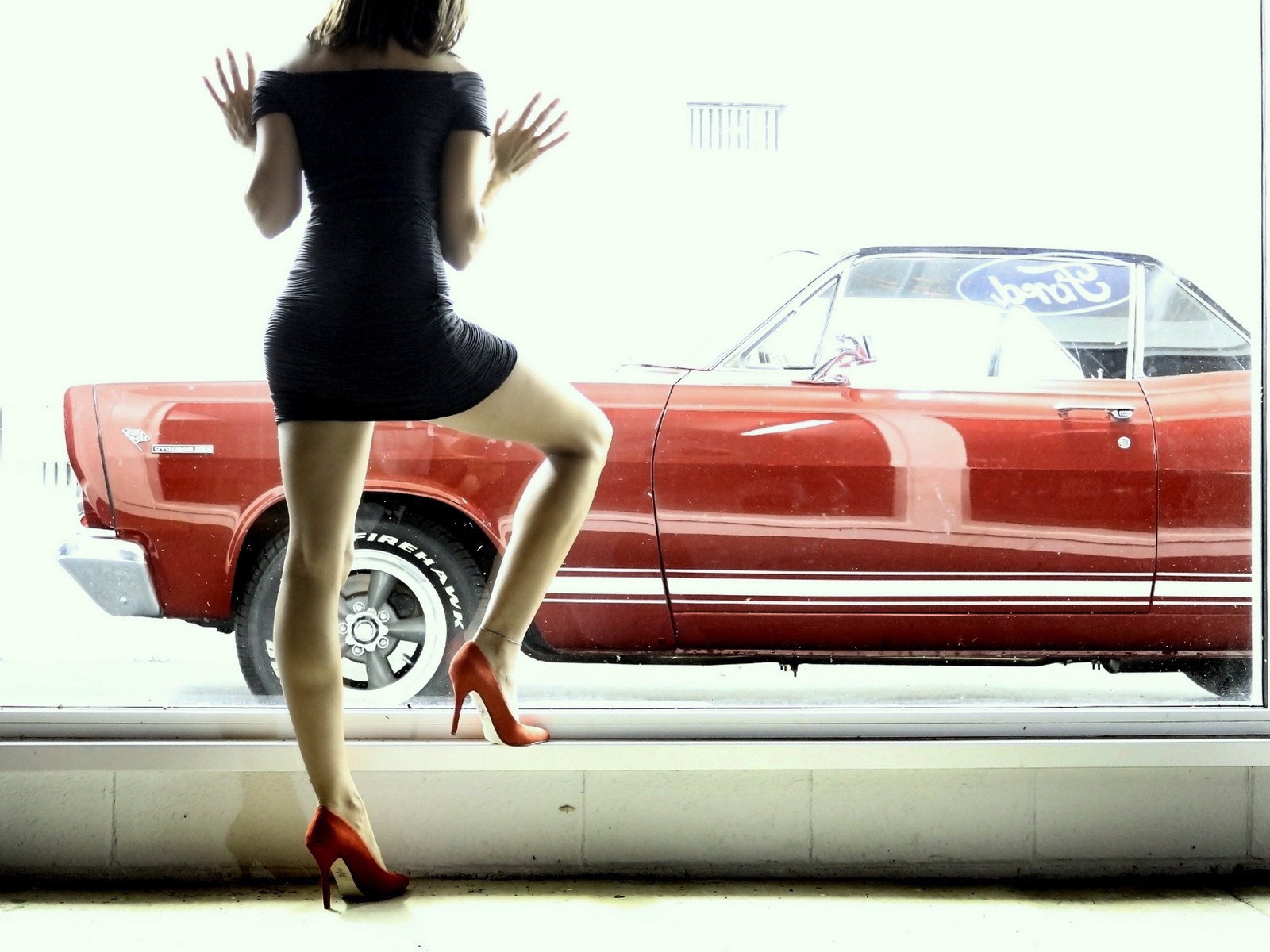 Девушка смотрит в окно на красный автомобиль