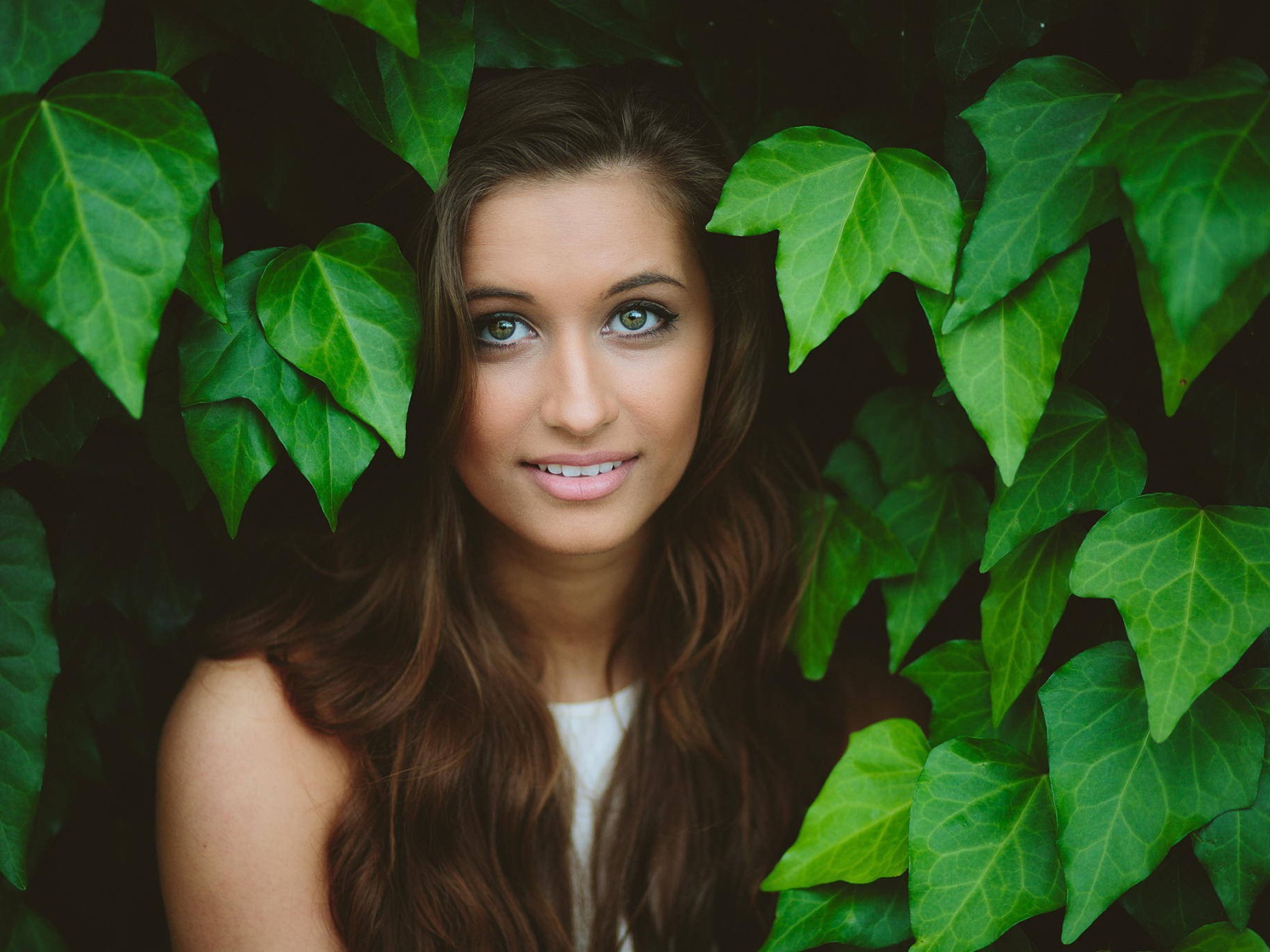Зеленоглазая девушка модель среди листьев