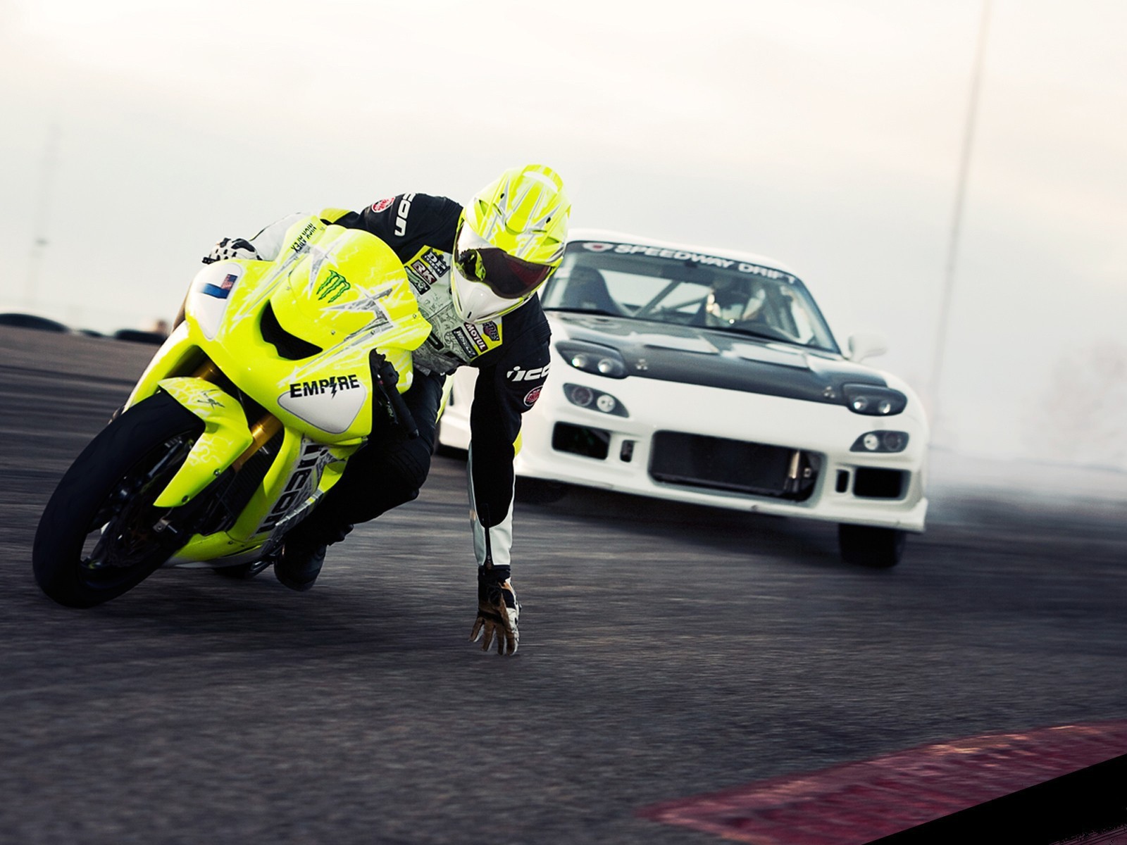 Мотоциклист касается рукой поверхности трека