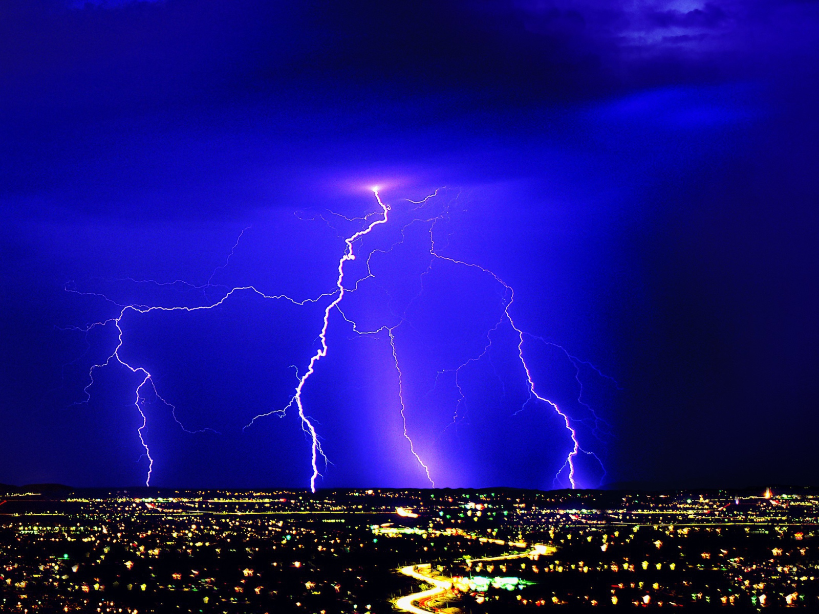 Lightning in a blue sky over night city
