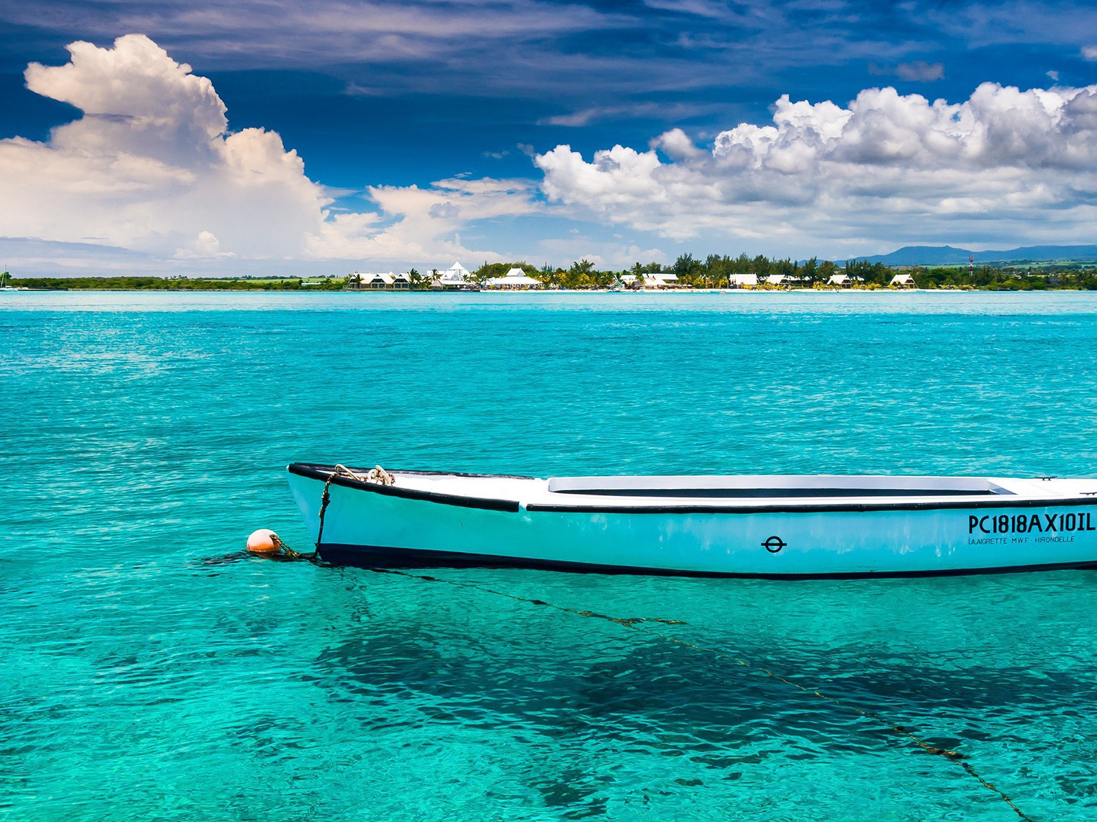 Белая лодка на голубой прозрачной воде