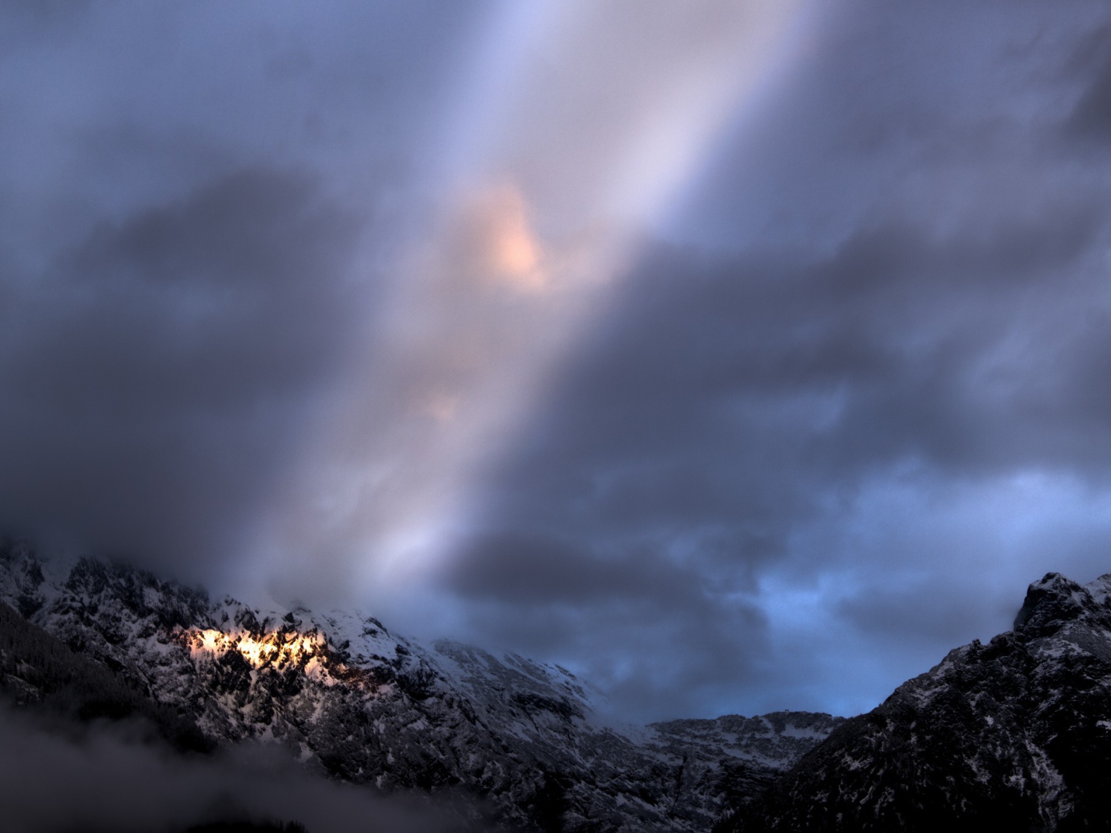 Луч солнца среди облаков в горах