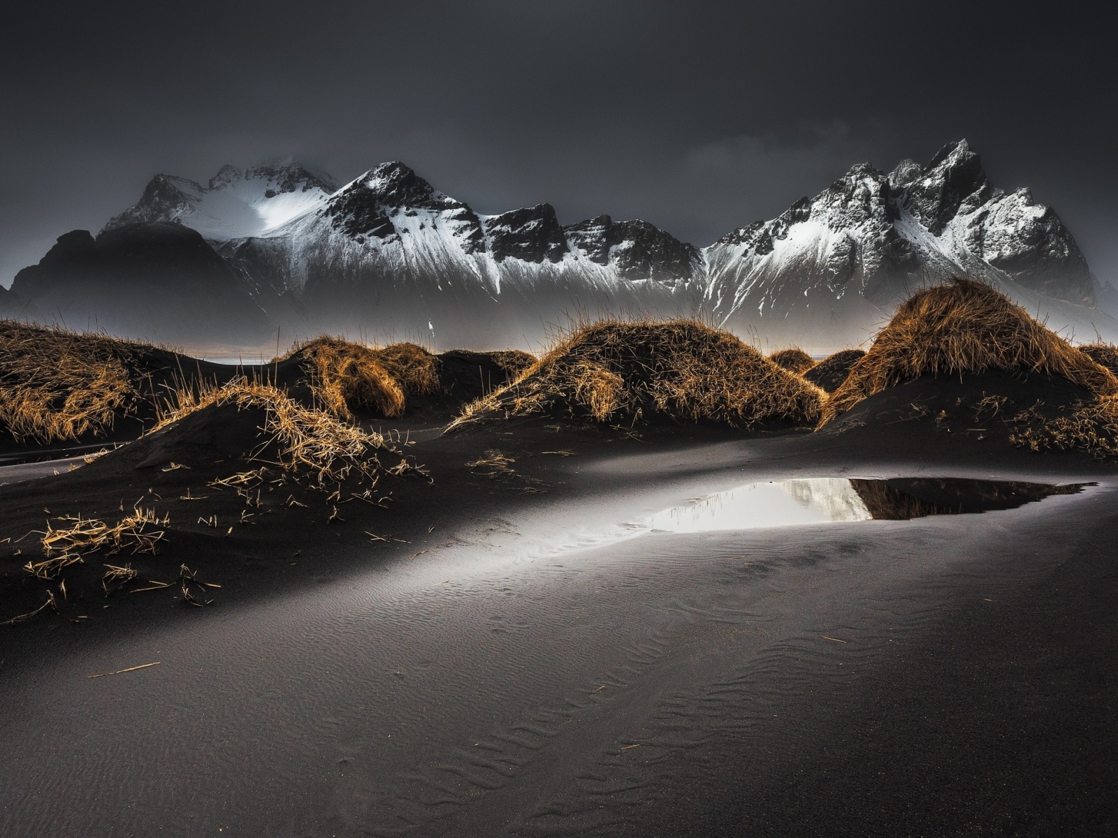 Серый песок на фоне гор