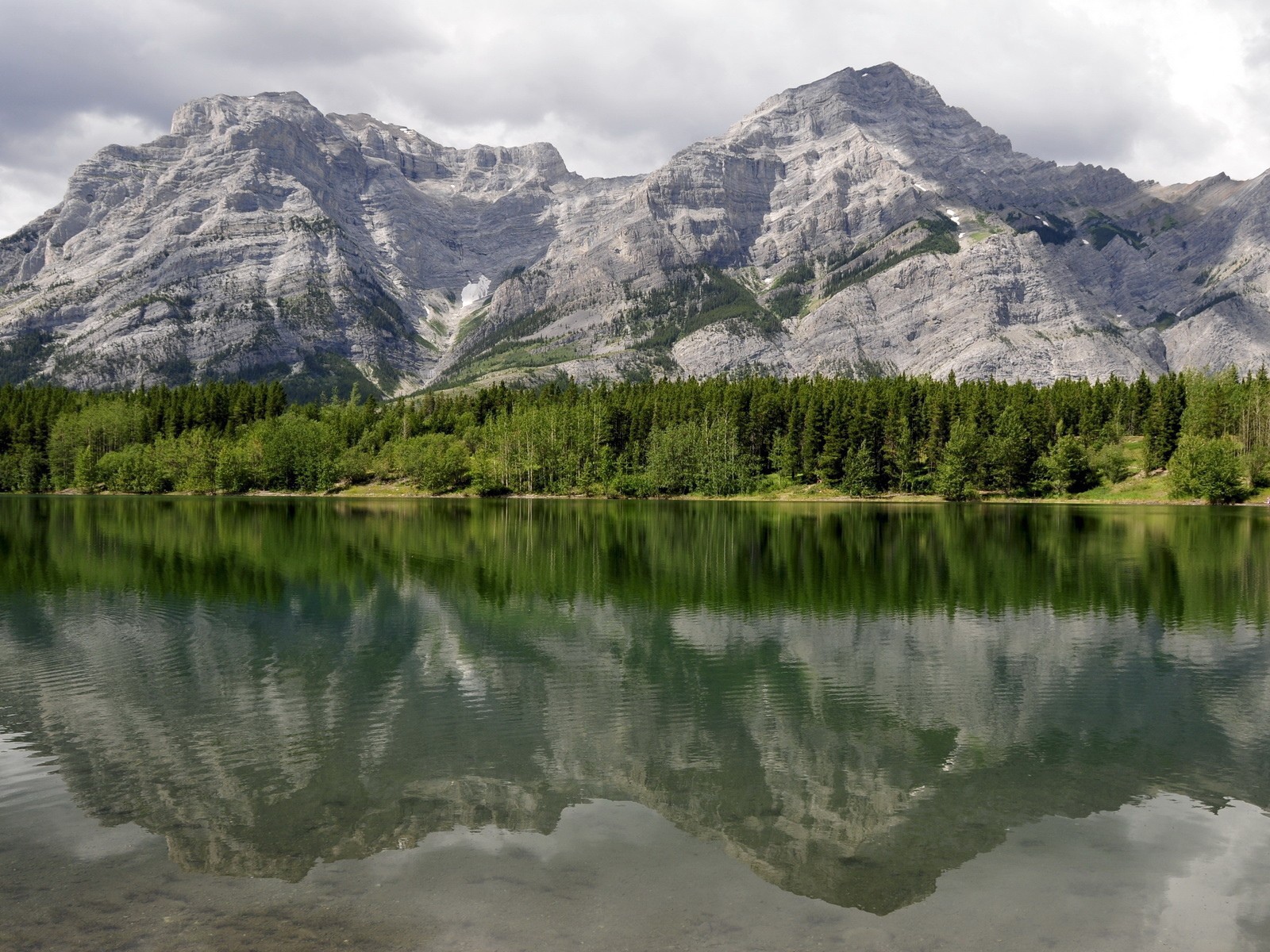 Горы и хвойный лес отражаются в горном озере
