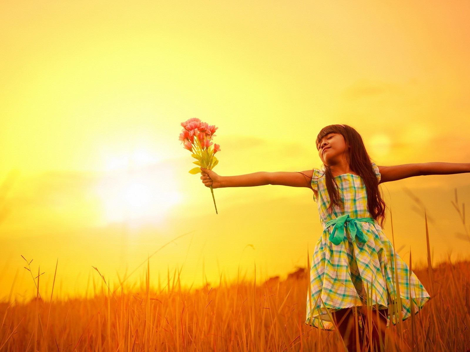 Девочка с букетом стоит в поле