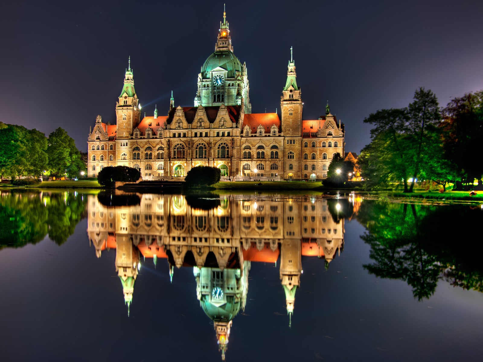 Освещенный замок с часами на башне