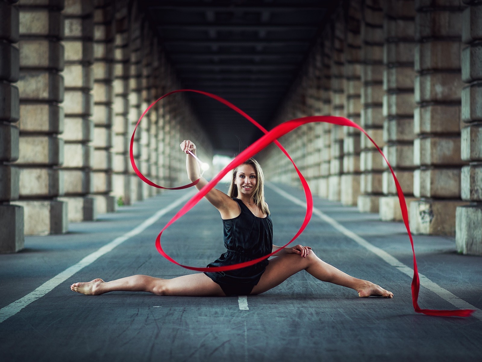 Гимнастка упражняется с красной лентой