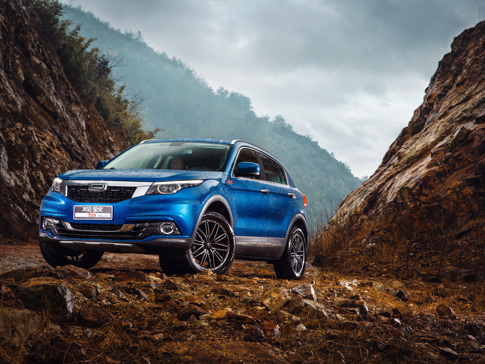 Синий китайский автомобиль Qoros 5  под дождем