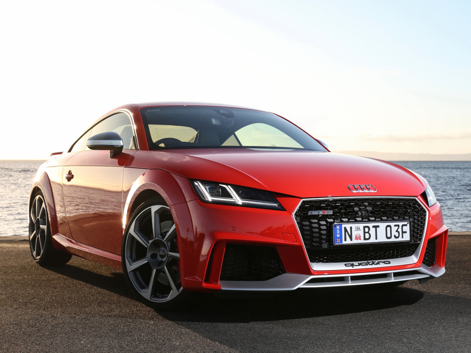 Красный автомобиль Audi TT на фоне океана
