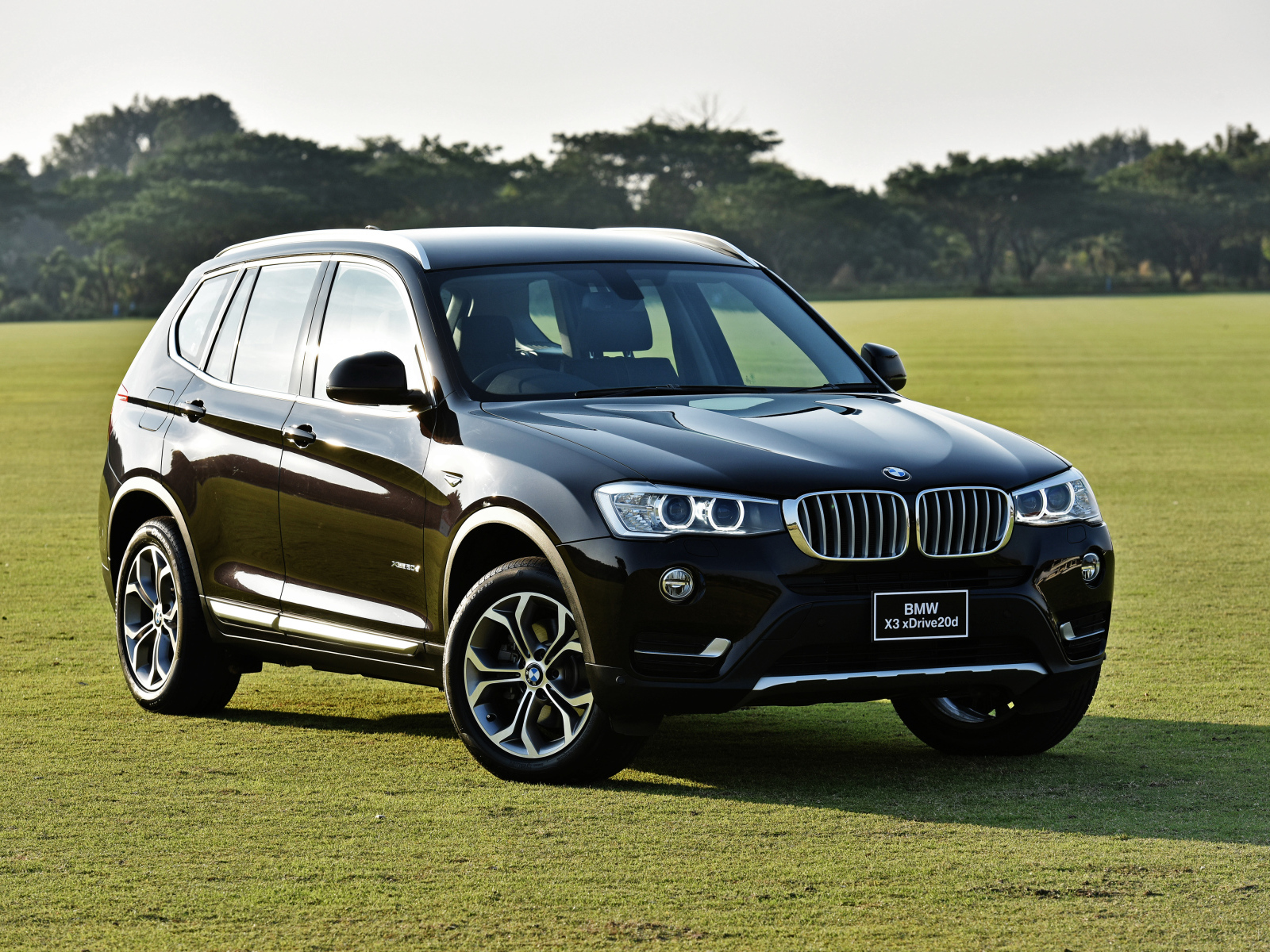 Черный автомобиль  BMW X3 на поле для гольфа 