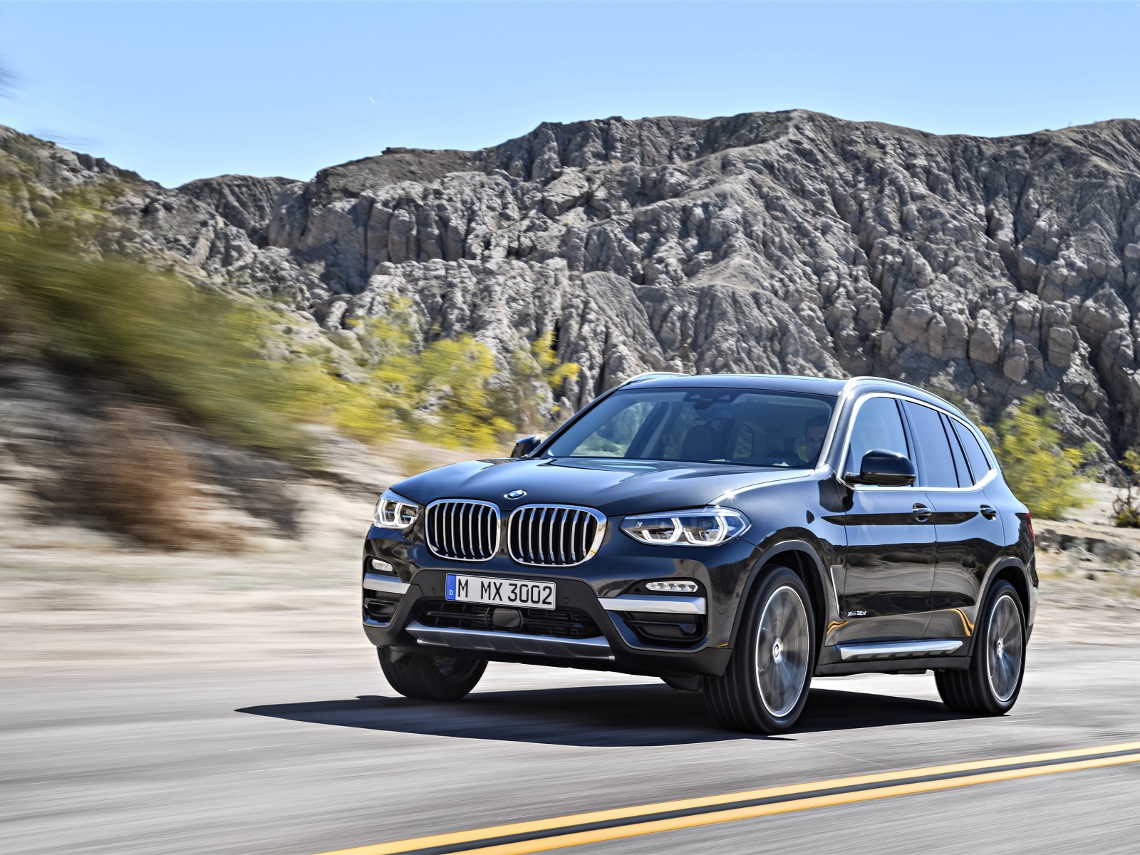 Черный красивый автомобиль BMW X3, 2018 на фоне гор