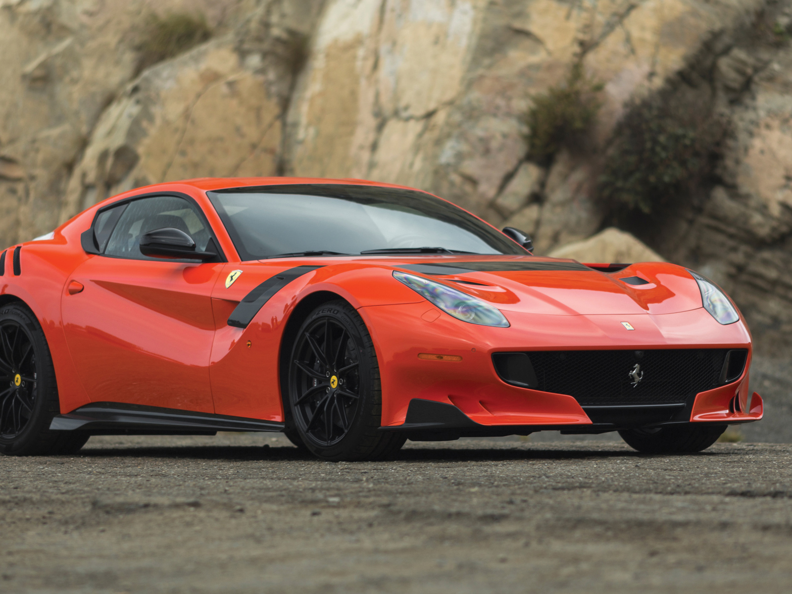 Красный спортивный автомобиль Ferrari F12tdf, 2017 у скалы