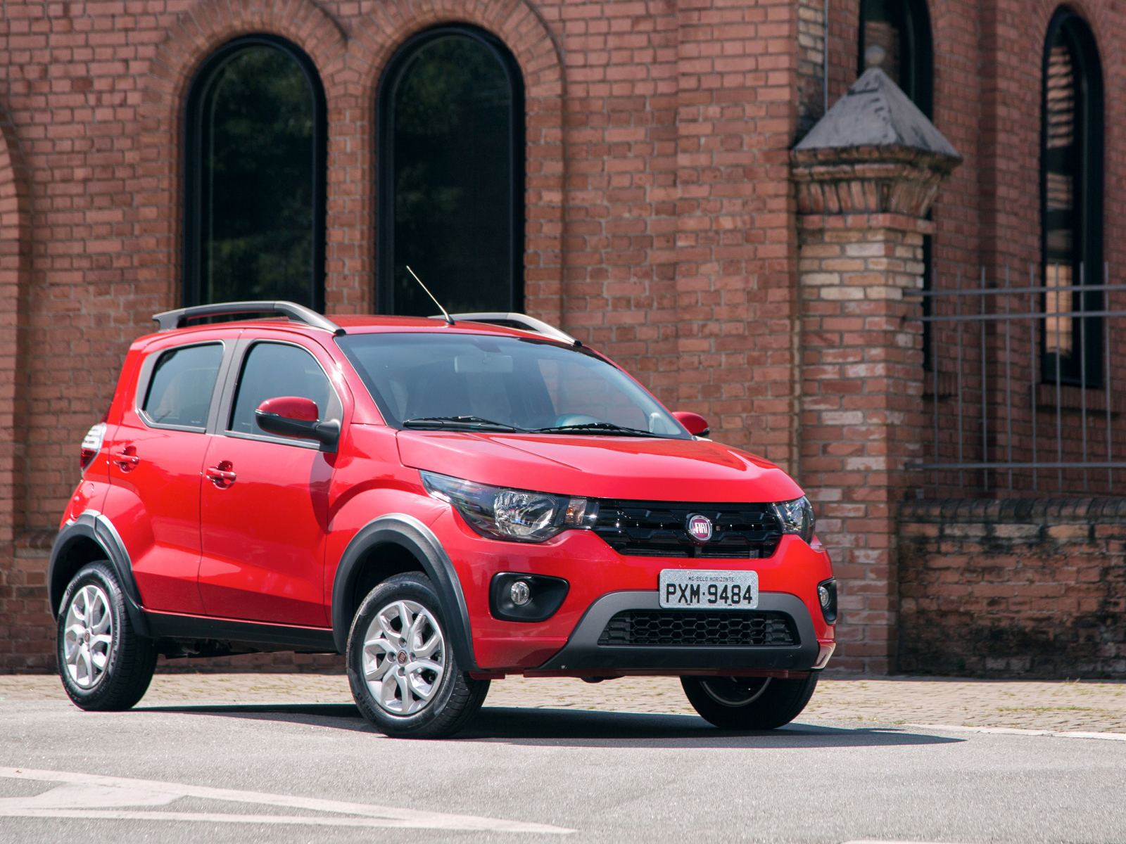 Красный автомобиль Fiat Mobi Way у здания