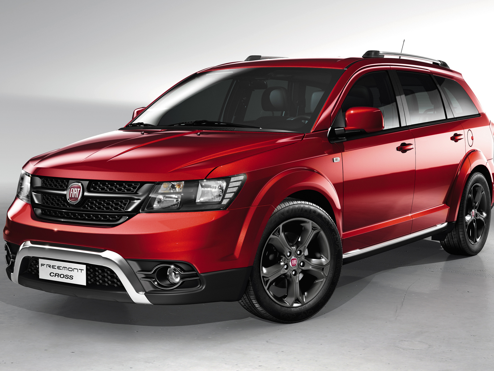 Красный автомобиль внедорожник Fiat Freemont Cross на сером фоне