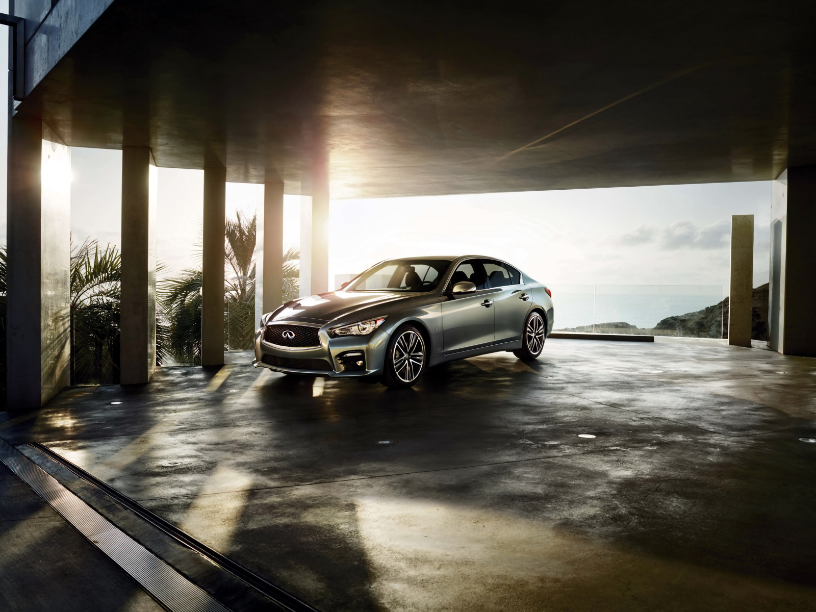 Серебристый автомобиль Infiniti Q50 в лучах солнца 