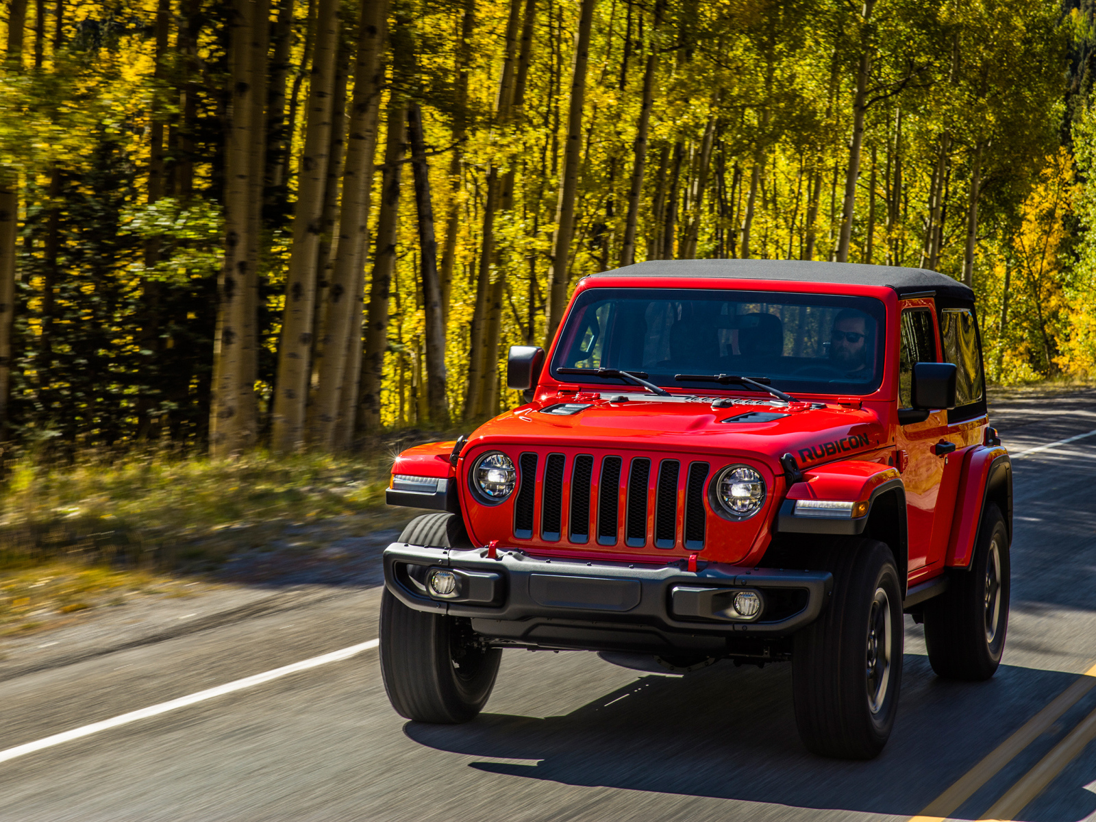 Красный автомобиль Jeep Wrangler Rubicon 2, 2018 на лесной трассе