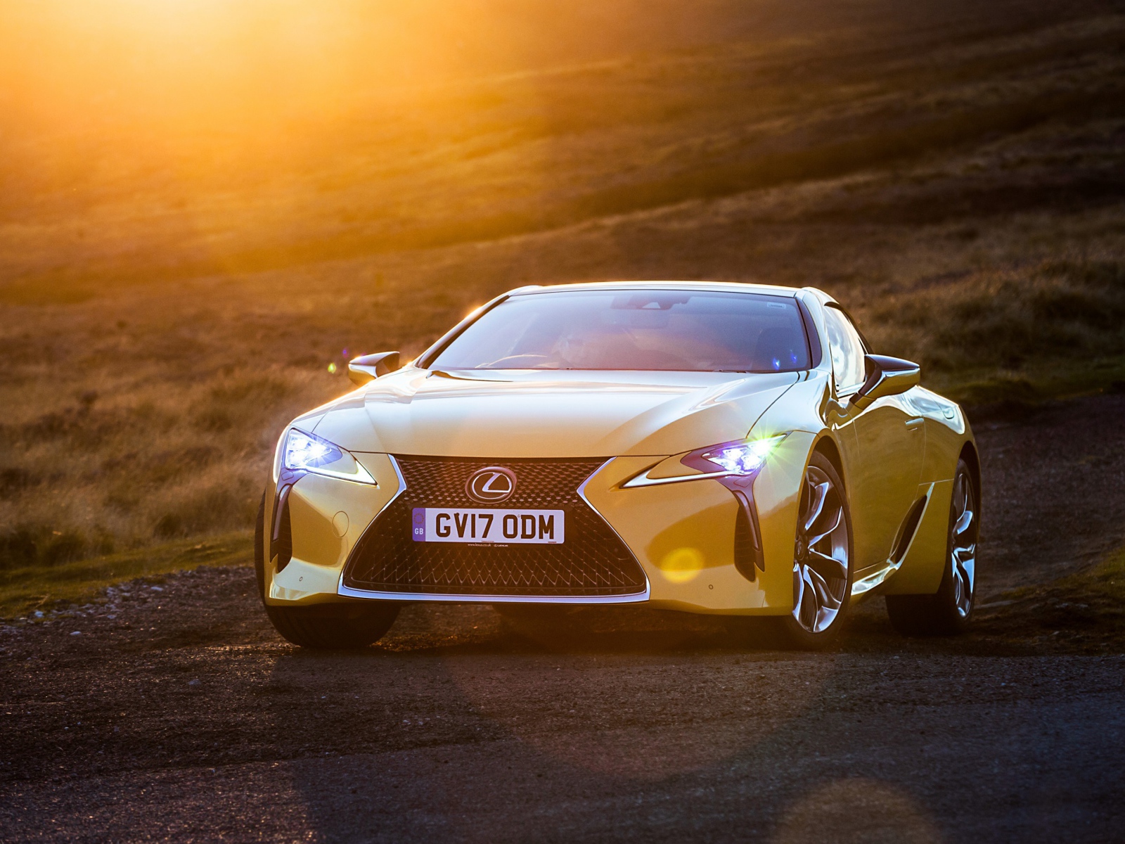 Желтый автомобиль Lexus LC 500, 2018 в лучах солнца