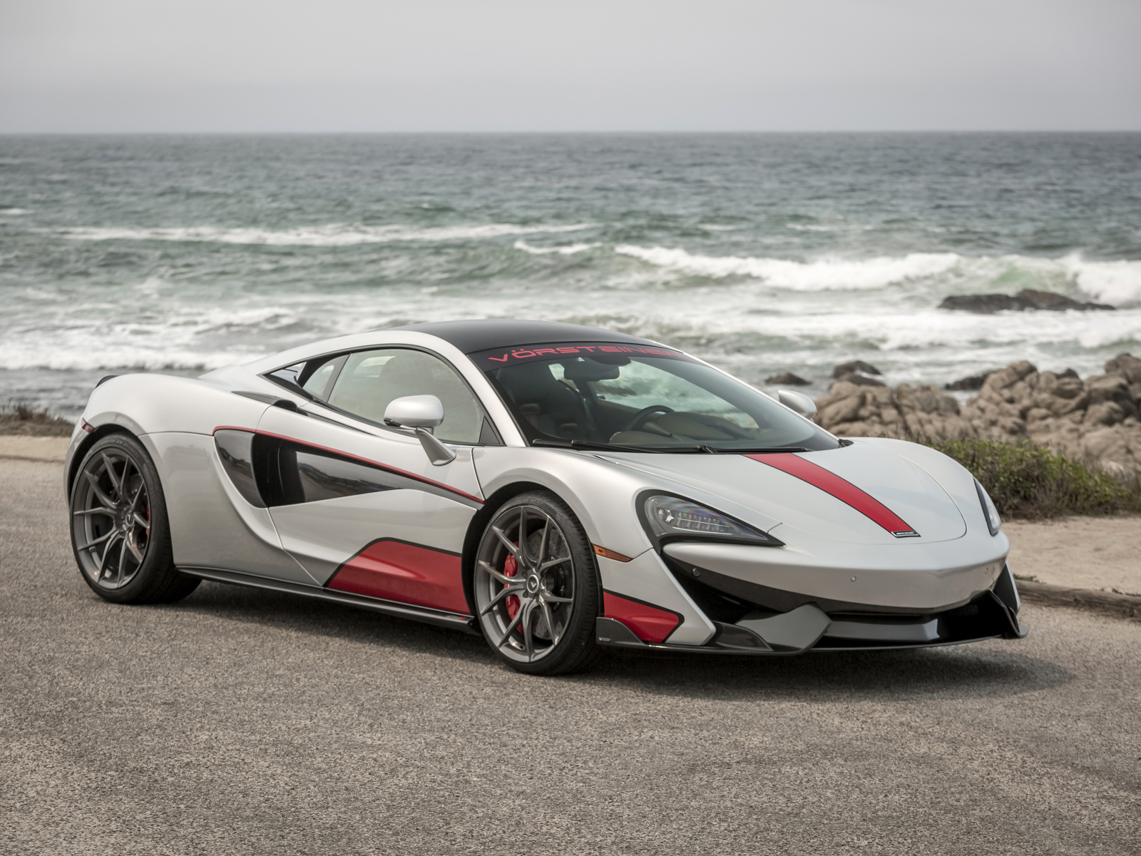 Спортивный автомобиль McLaren 570S на фоне океана