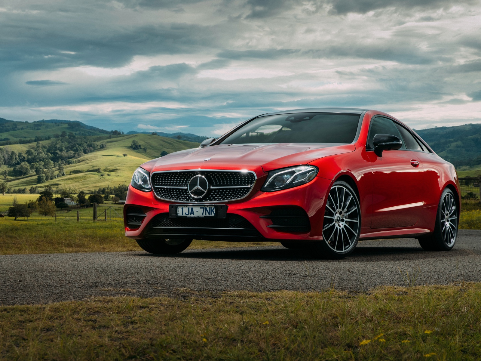 Красный автомобиль Mercedes-Benz E-Class на фоне природы