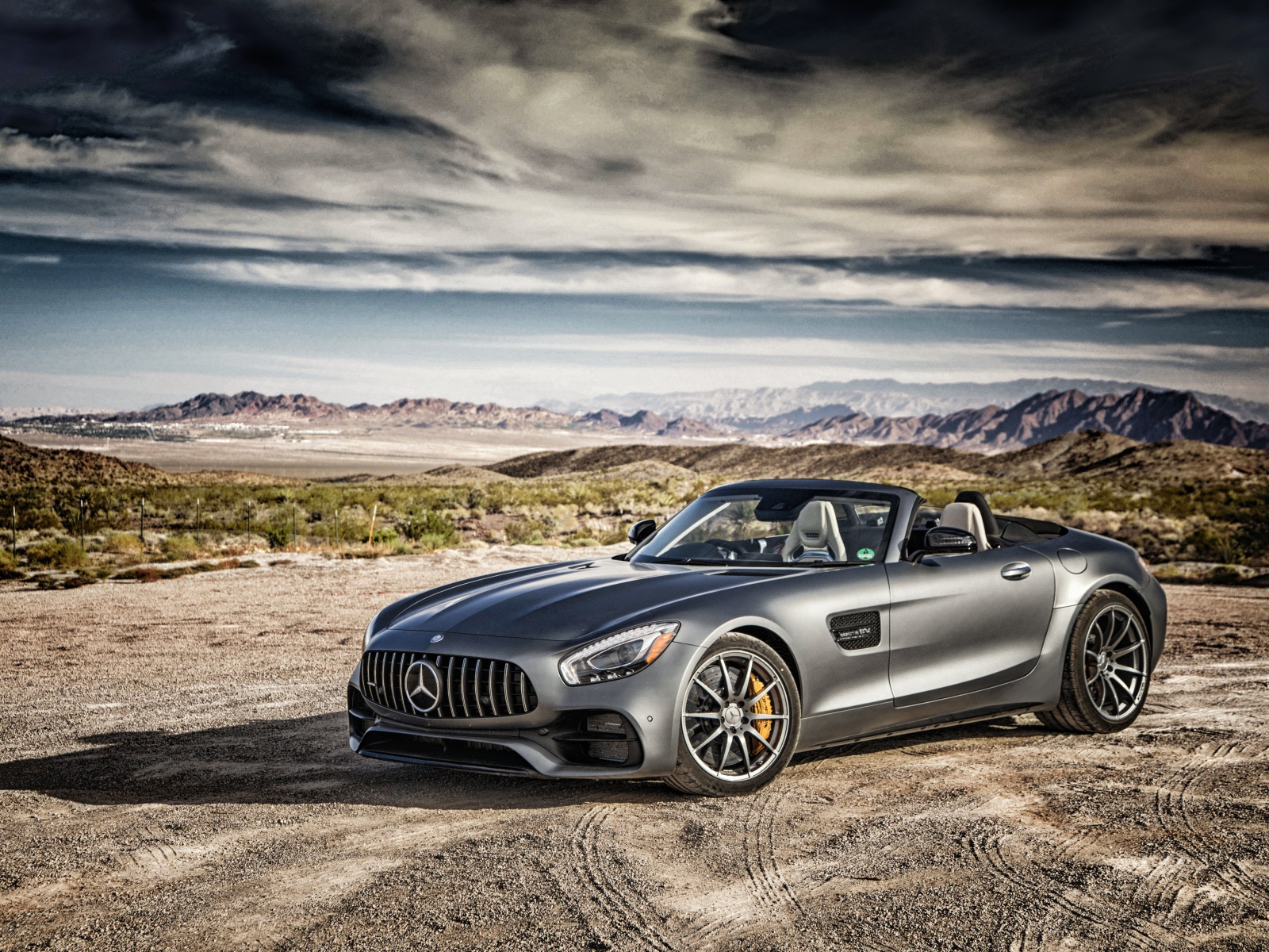 Серебристый автомобиль Mercedes-AMG GT на фоне неба