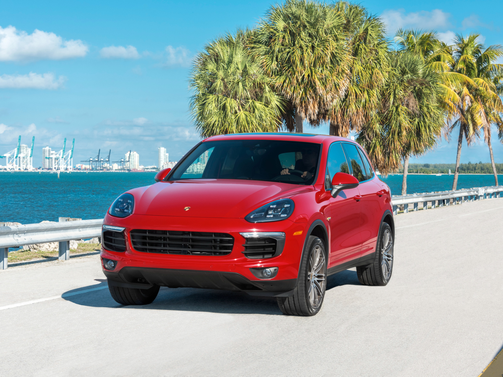 Красный внедорожник Porsche Cayenne на фоне океана