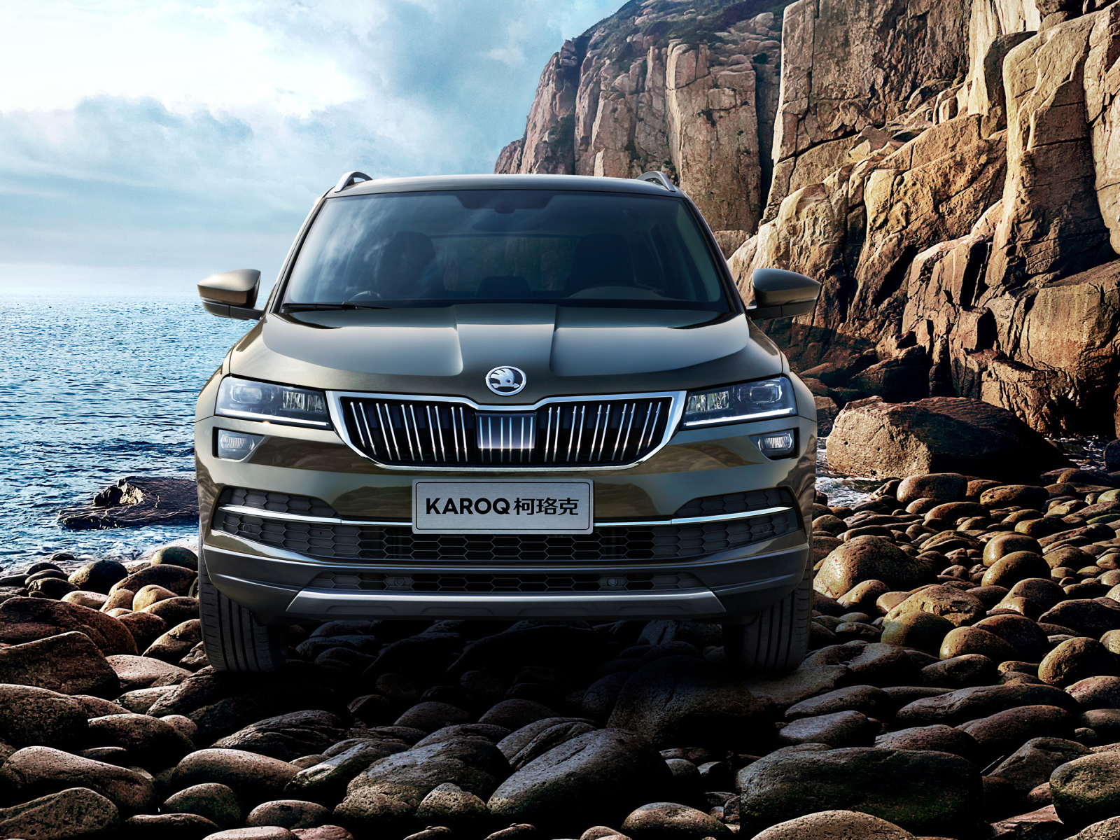 Внедорожник Skoda Karoq на камнях у скалы на фоне океана