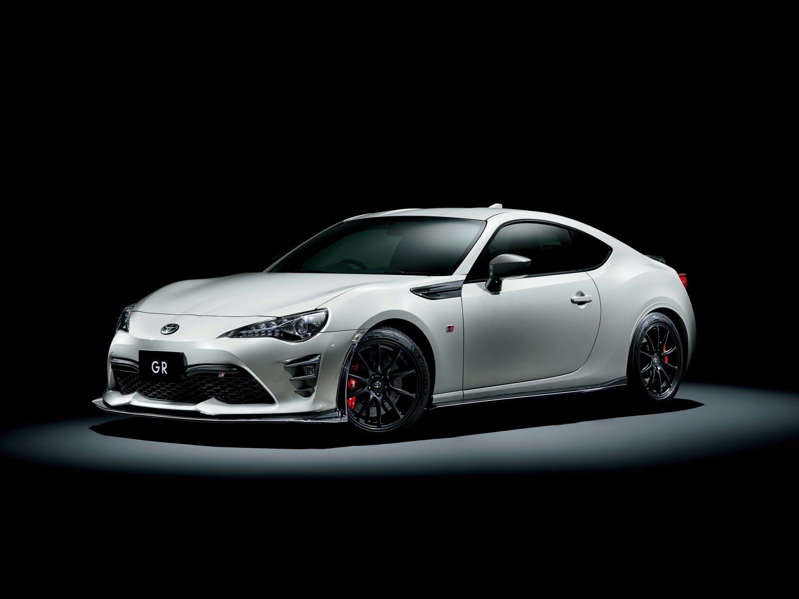 Белый спортивный автомобиль Toyota 86 GR на черном фоне