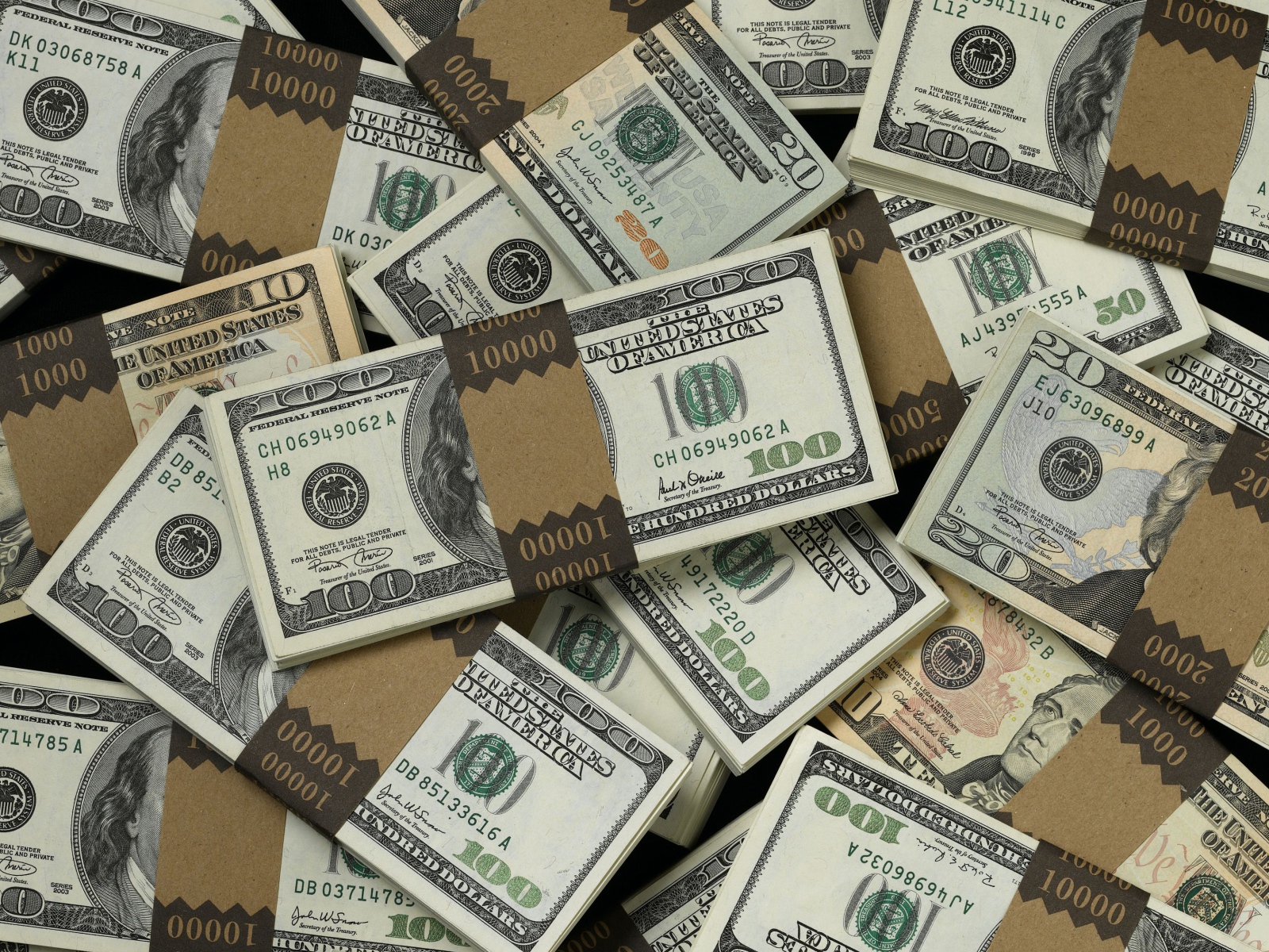 Много пачек купюр по сто долларов