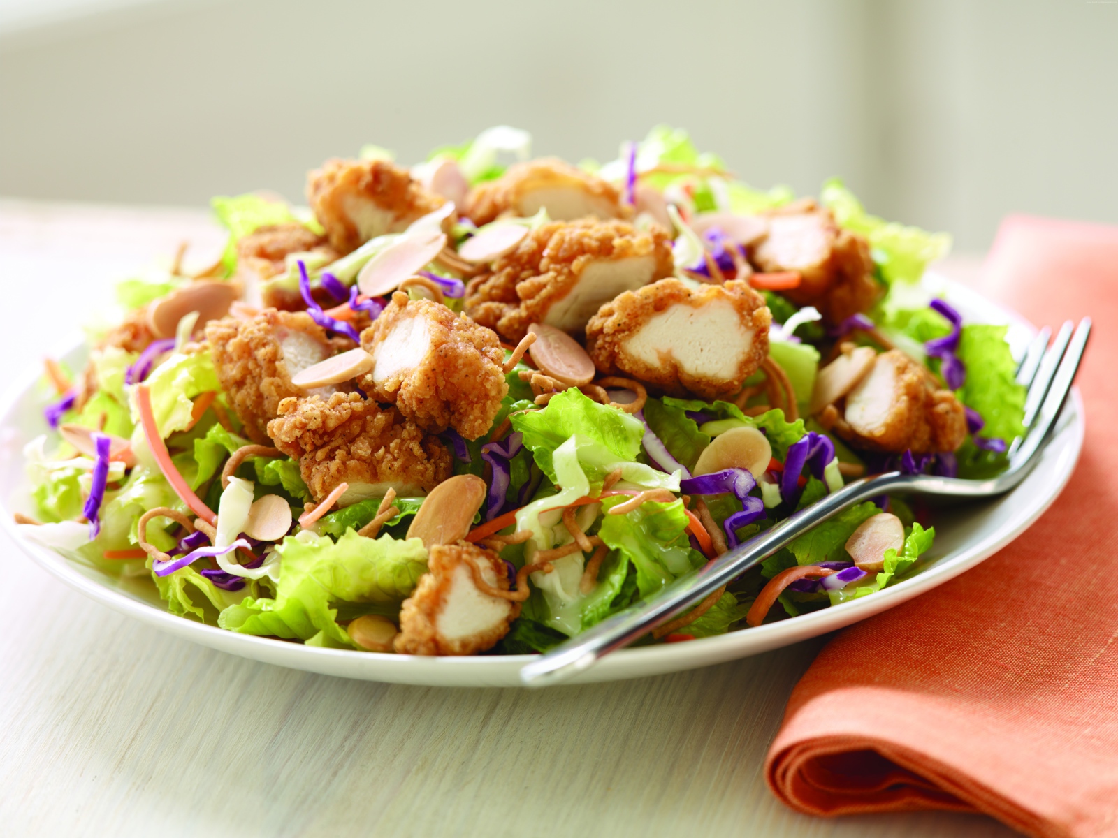Куриный салат с орехами и капустой на тарелке
