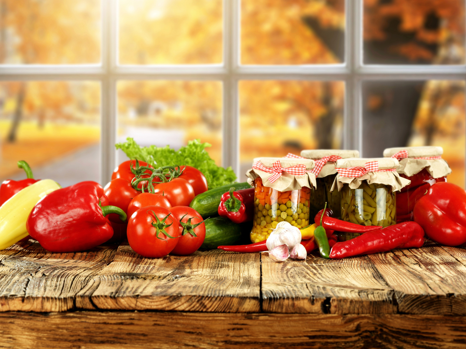 Свежие овощи и зимние заготовки на столе 