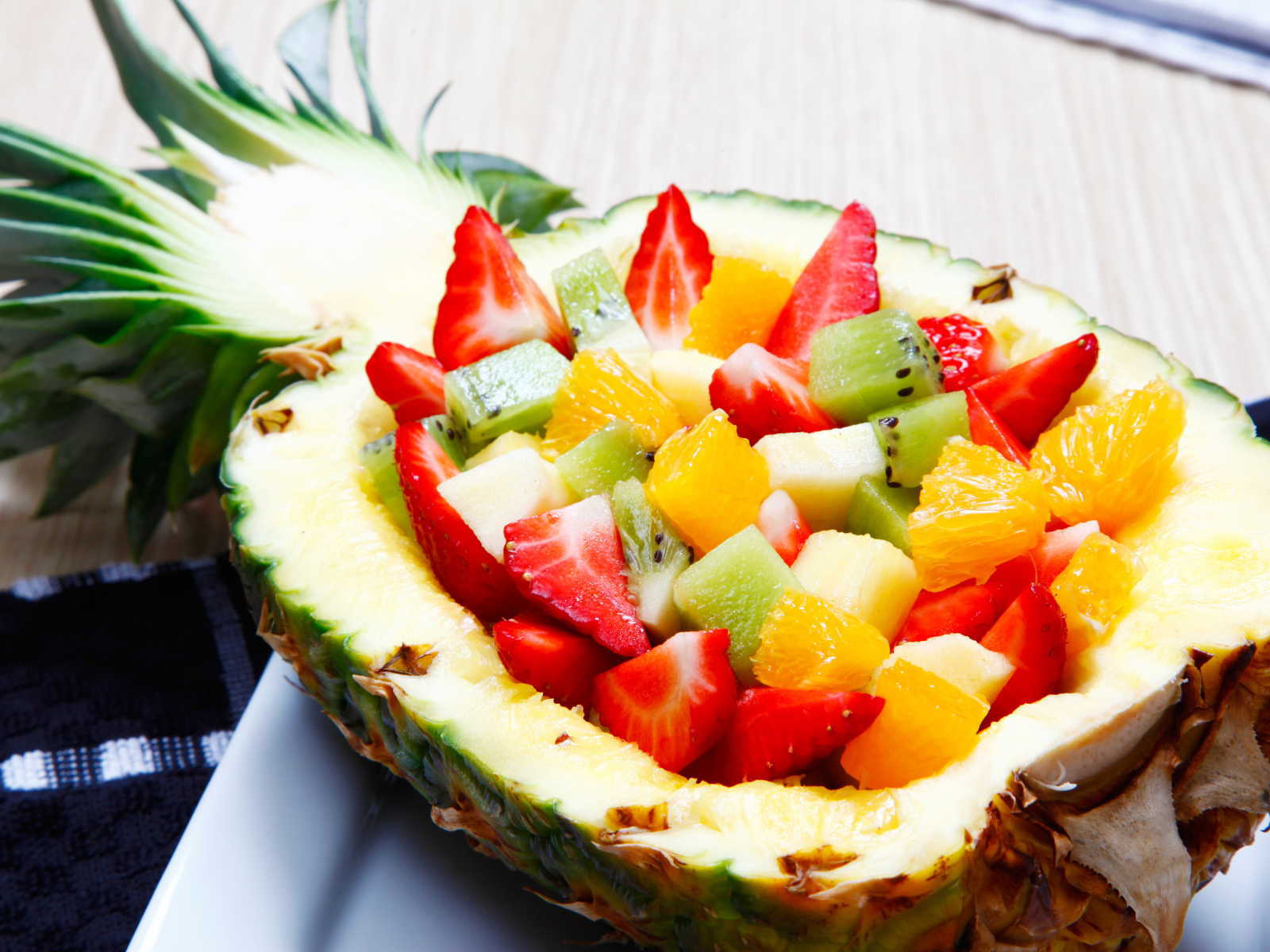 Фруктовый салат из цитрусовых  в тарелке из свежего ананаса 