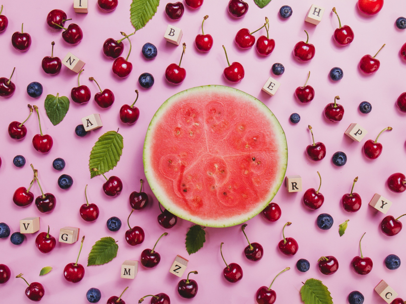 Половина арбуза с ягодами вишни и черники на столе