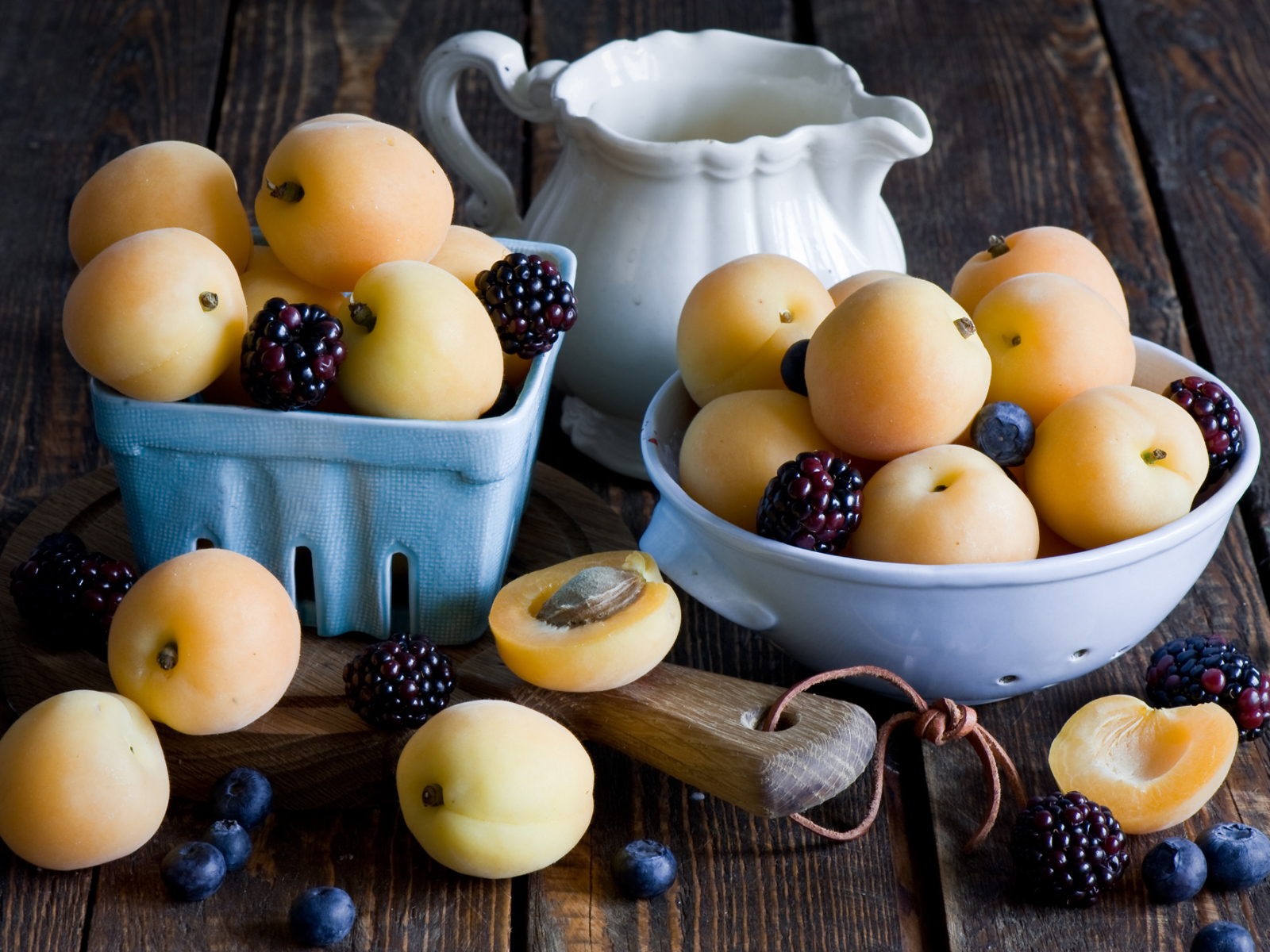 Спелые абрикосы и ягоды на столе 