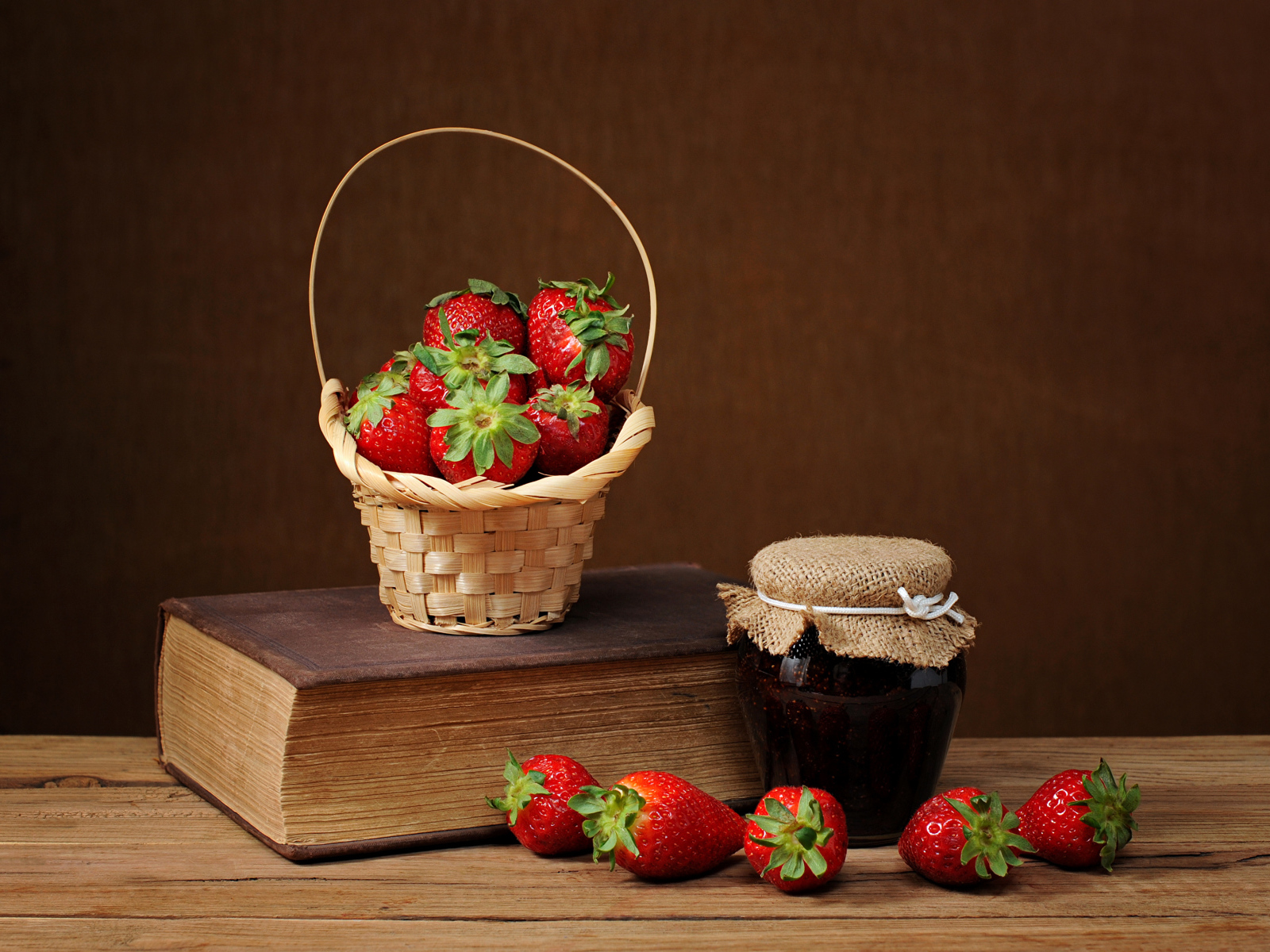 Клубничный джем, свежая клубника и книга на столе