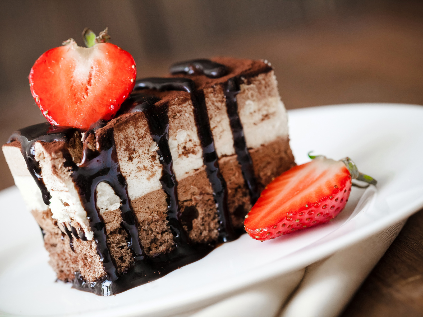Кусок шоколадного пирожного со свежей клубникой