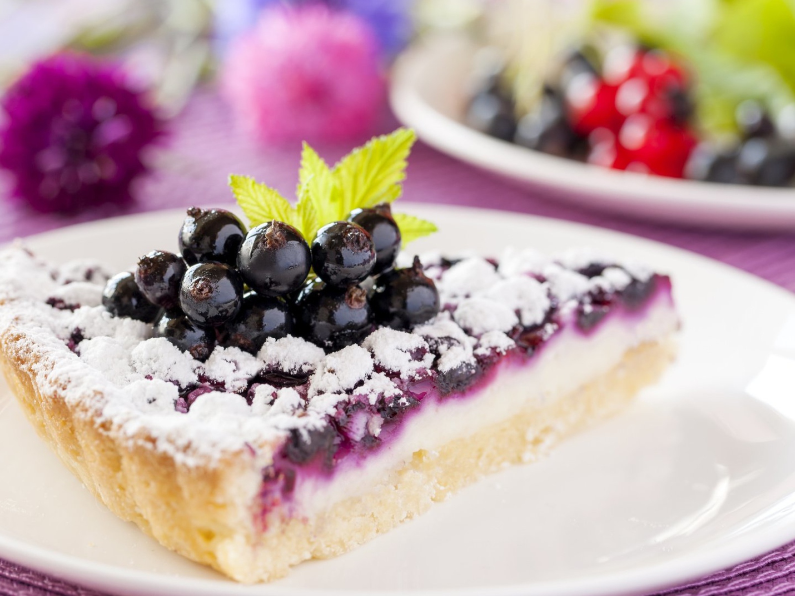 Кусок пирога с черной смородиной и сахарной пудрой