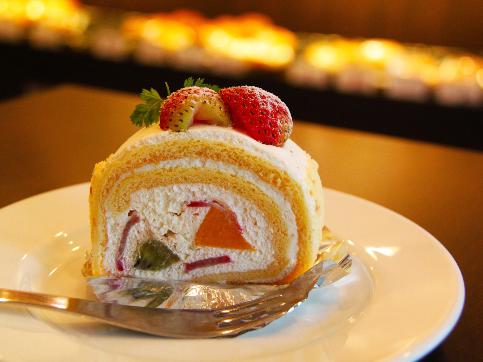 Кусок сладкого бисквитного рулета с клубникой 