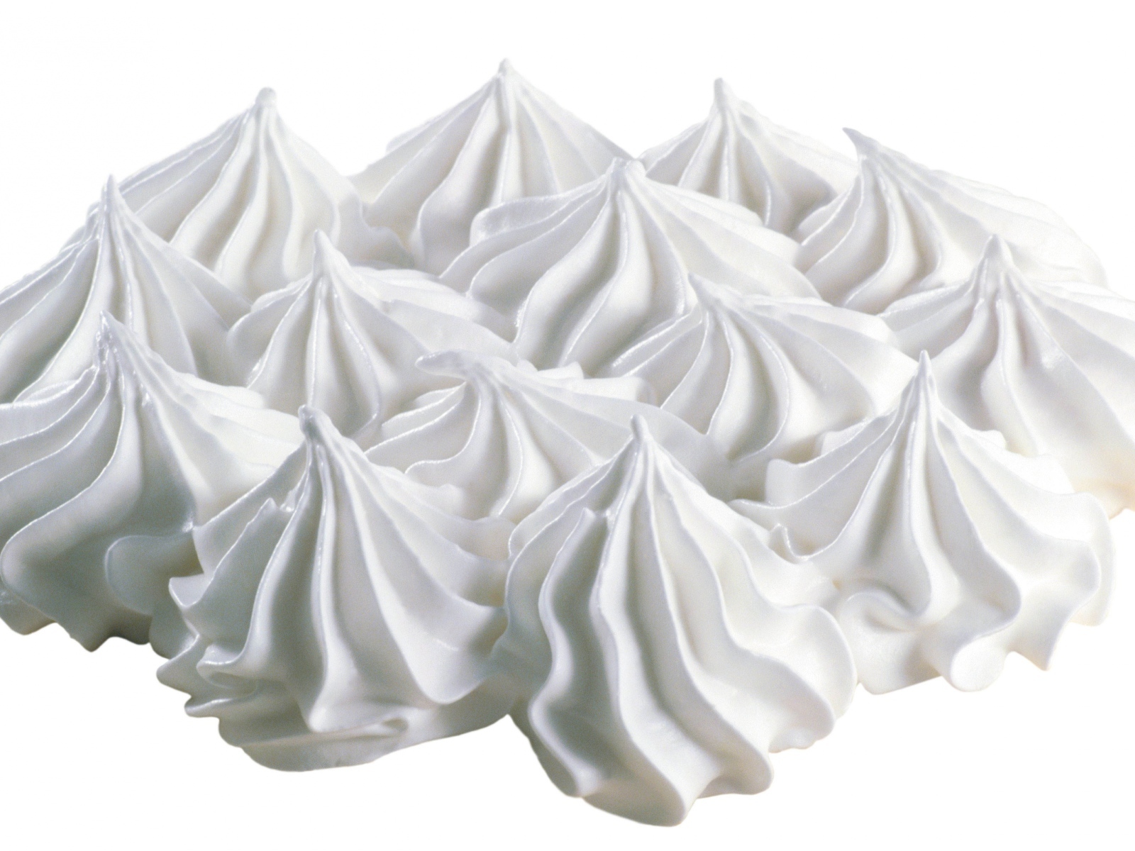 Воздушные взбитые сливки на белом фоне