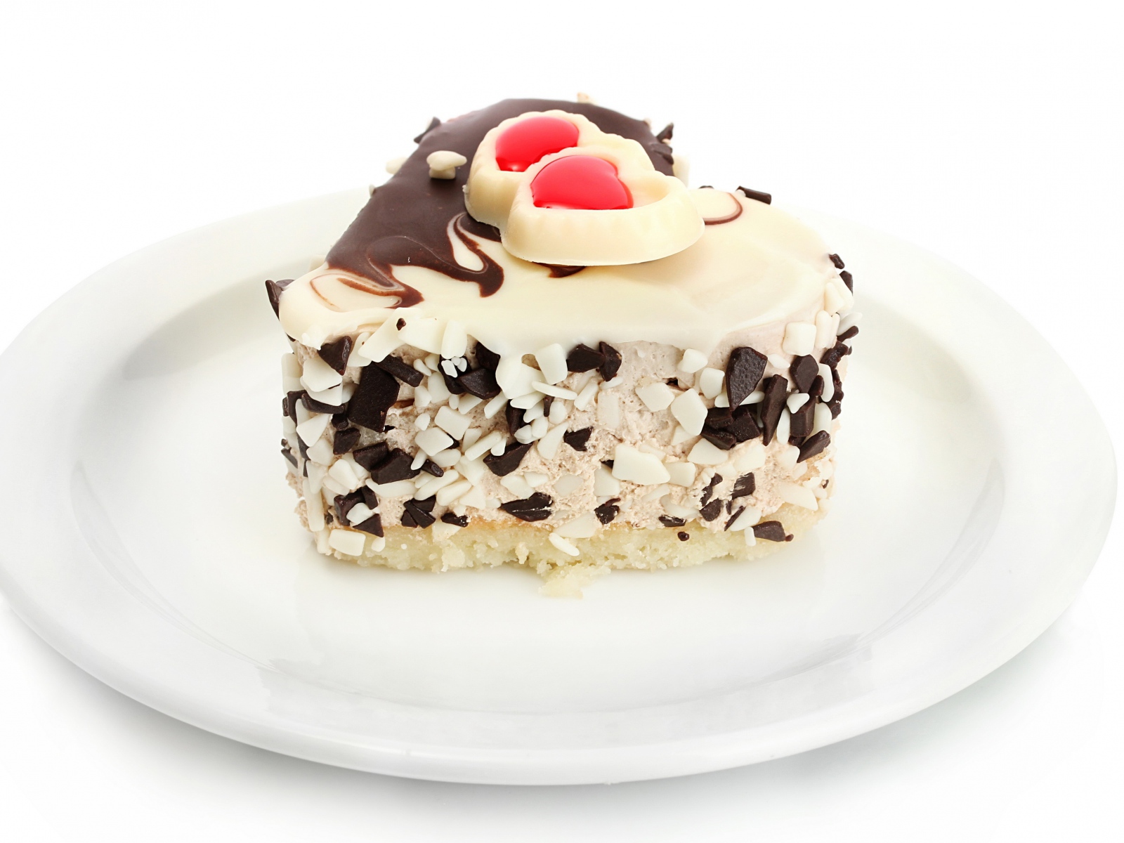 Аппетитное пирожное в форме сердца с шоколадом на белой тарелке