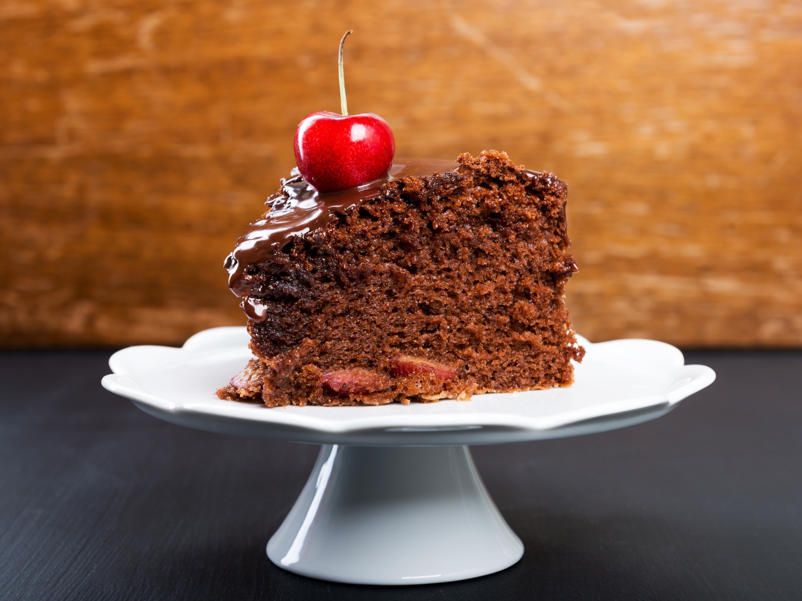 Аппетитный кусок пирога с шоколадом и ягодой черешни