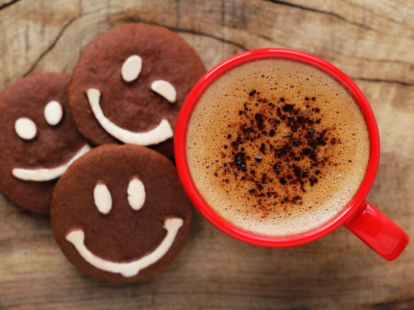 Шоколадное печенье смайлы на столе с чашкой кофе