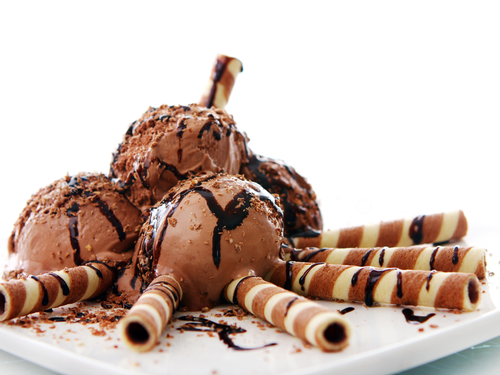 Шоколадное мороженое с трубочками на белом фоне