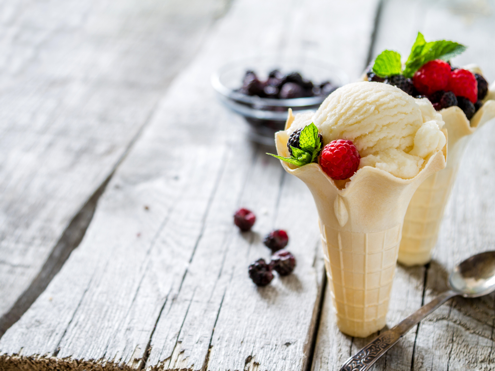 Сливочное мороженое в вафельном стаканчике с ягодами