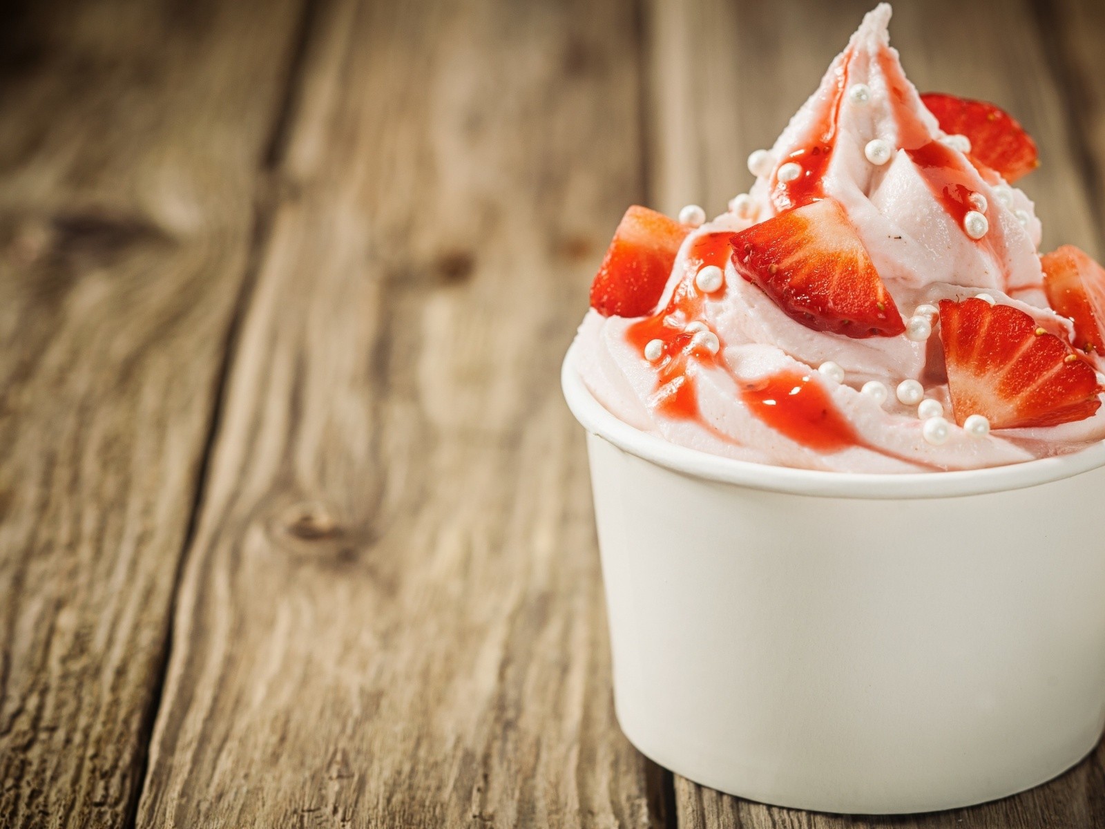 Мороженое с клубникой в белом стакане 