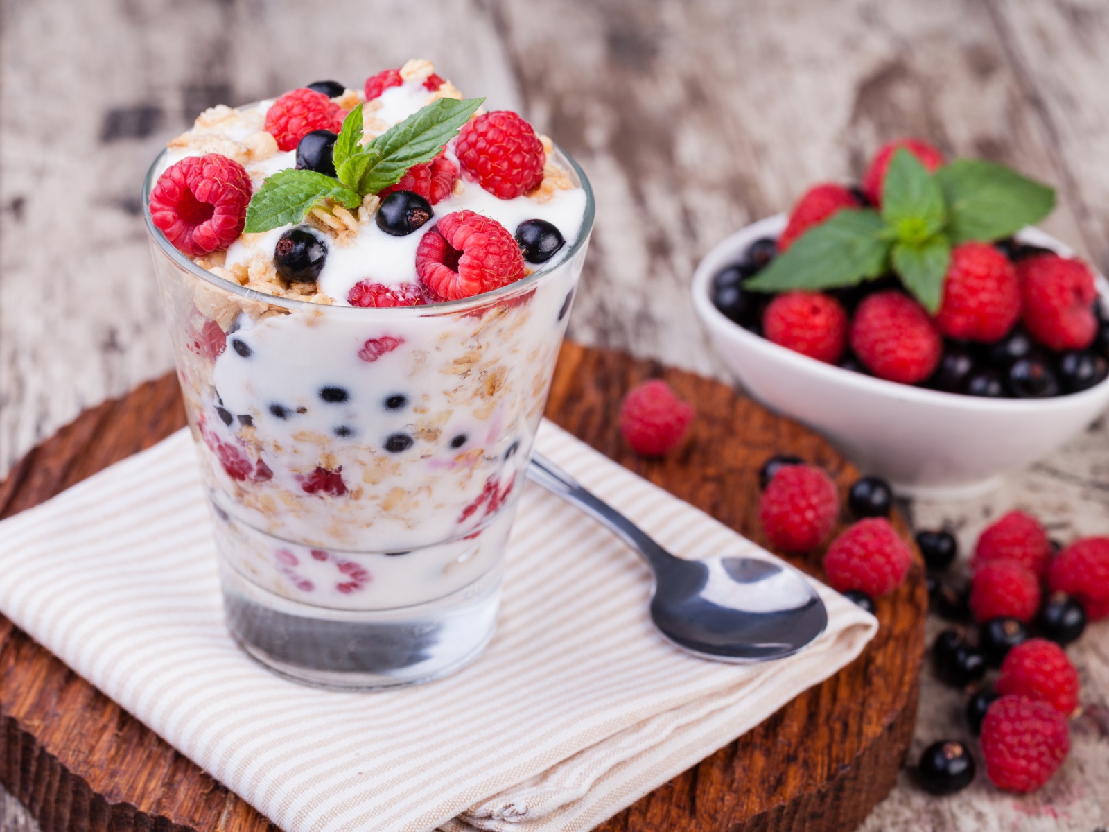 Сладкий десерт с овсяными хлопьями, йогуртом и ягодами малины и смородины