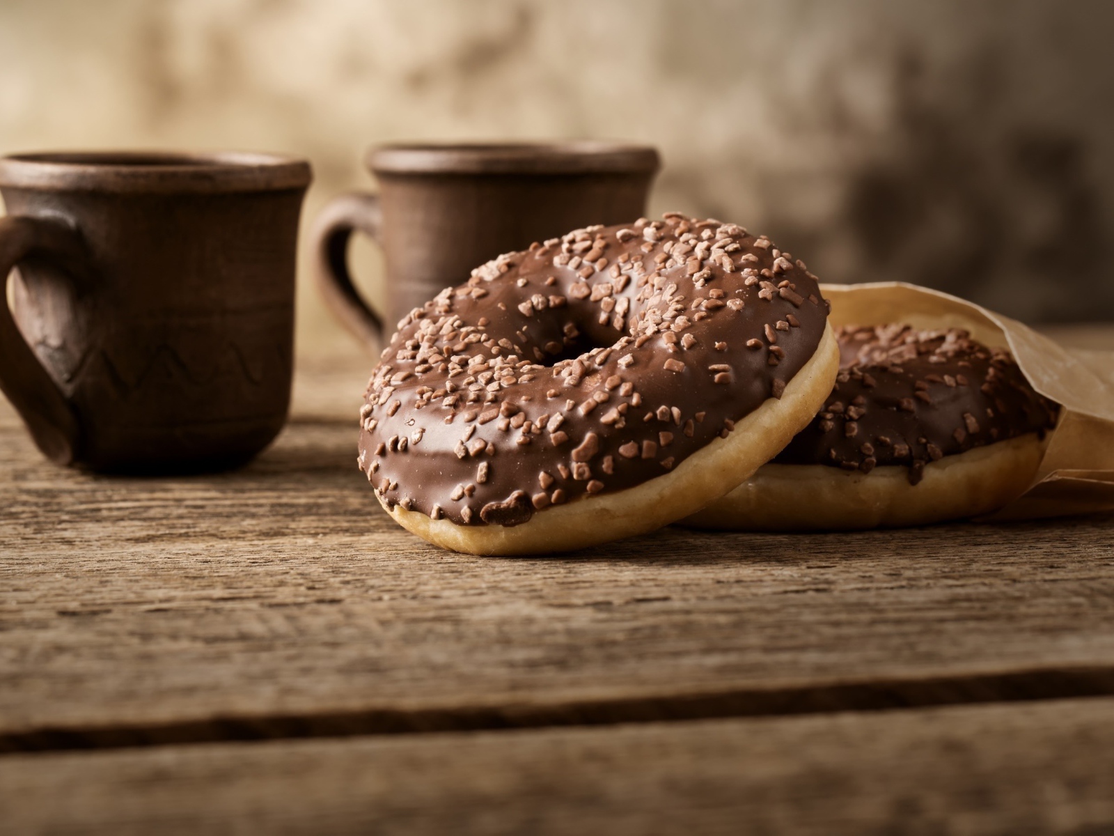 Сладкие круглые пончики с шоколадом на столе 