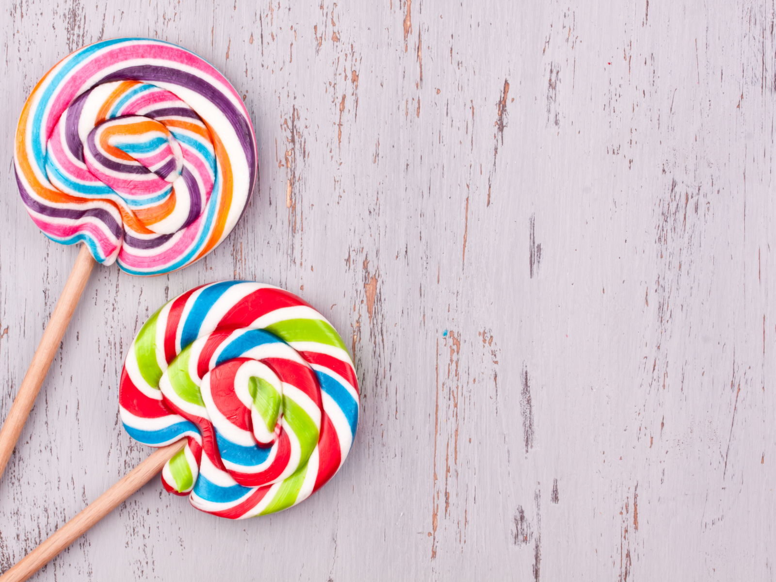 Две разноцветных конфеты на палочке