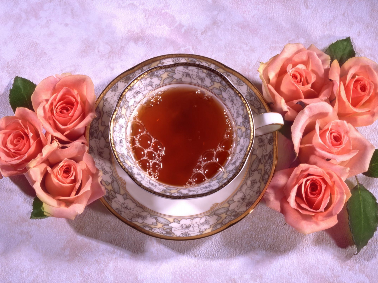 Красивая чашка черного чая на столе с розовыми розами